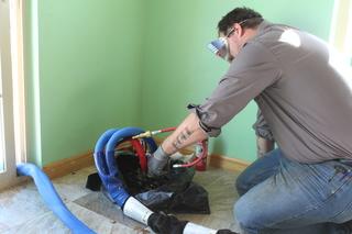 Production leader, Adam Blake installing PolyLevel with protective gear and cover to protect finished areas.
