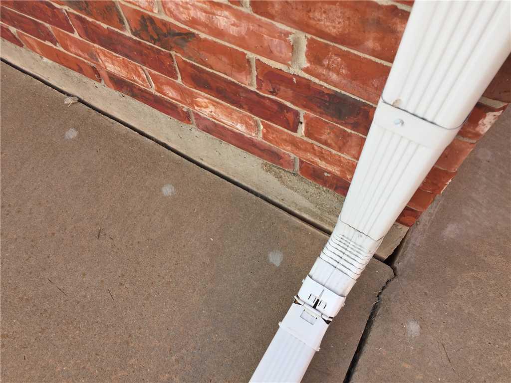 During heavy rains, this gutter allows water to run underneath the concrete and wash the underlayment out causing settlement.