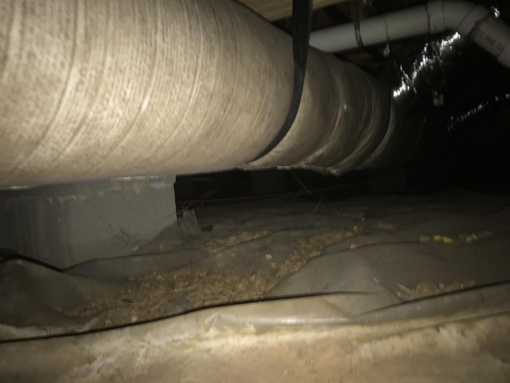 Debris and exposed soil in a crawl space that isn't encapsulated